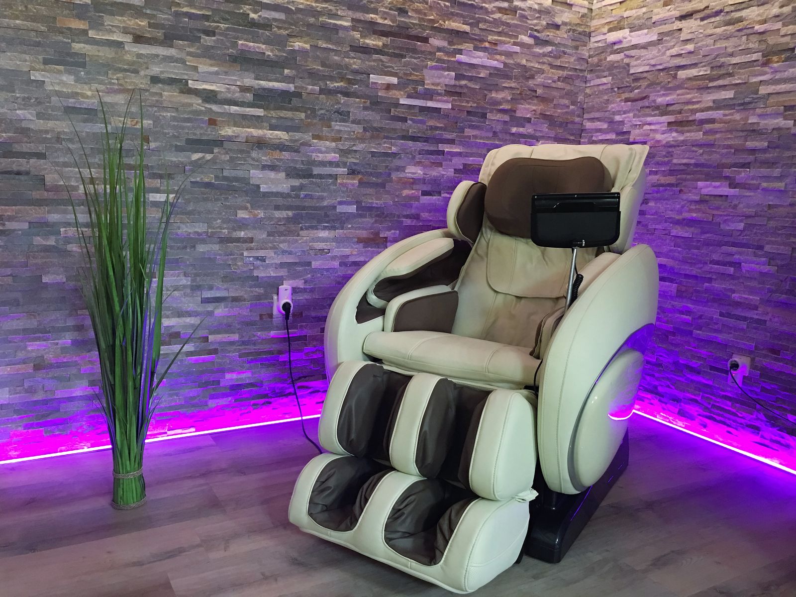 Massagesessel vor beleuchteter Steinwand
