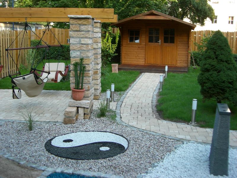 Yin-Yang-Mosaik im Kiesbeet vor dem Gartenhaus